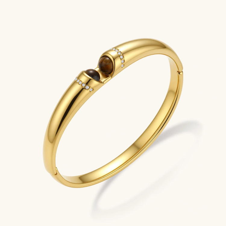 Polished gold bangle with two oval tiger&