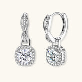 Sterling silver twisted hoop earrings with round moissanite stones in halo settings against neutral background.