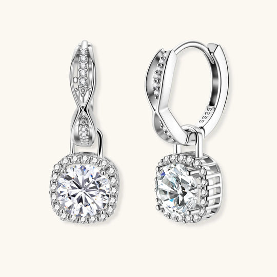 Sterling silver twisted hoop earrings with round moissanite stones in halo settings against neutral background.