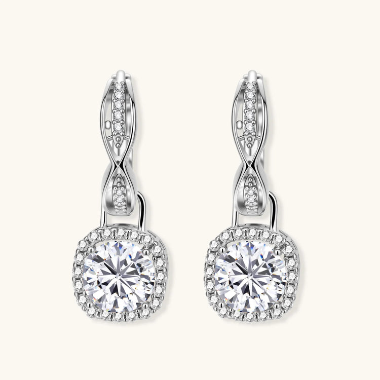 Sterling silver twisted hoop earrings with round moissanite stones in halo settings against neutral background.