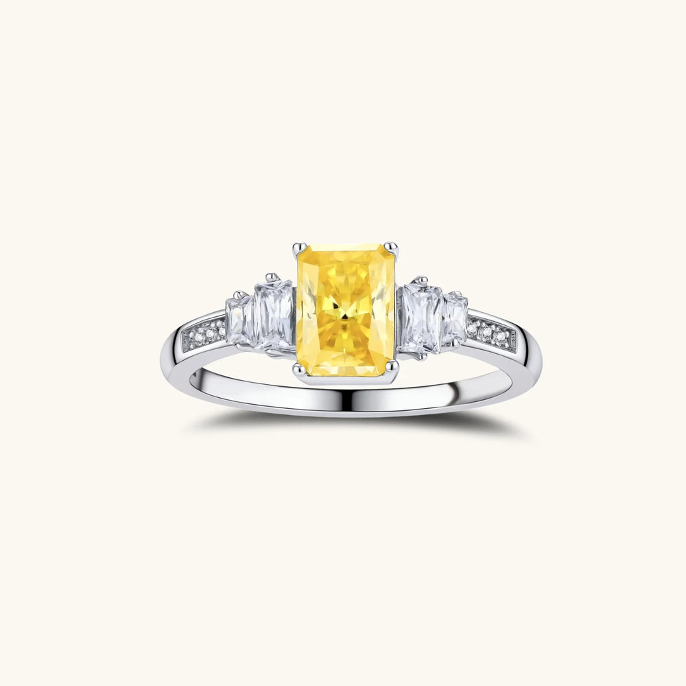 Yellow moissanite jewelry set with emerald-cut stones in sterling silver halo settings on white background.