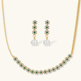 Gold-plated jewelry set with green cubic zirconia floral motifs, featuring matching necklace and pearl drop earrings