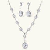 Elegant white gold plated jewelry set with oval cubic zirconia stones in halo settings, featuring Y-necklace and drop earrings.