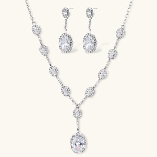 Elegant white gold plated jewelry set with oval cubic zirconia stones in halo settings, featuring Y-necklace and drop earrings.
