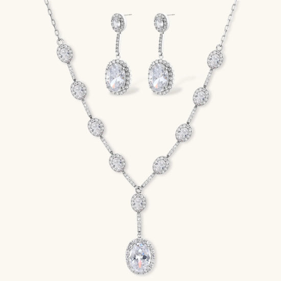 Elegant white gold plated jewelry set with oval cubic zirconia stones in halo settings, featuring Y-necklace and drop earrings.