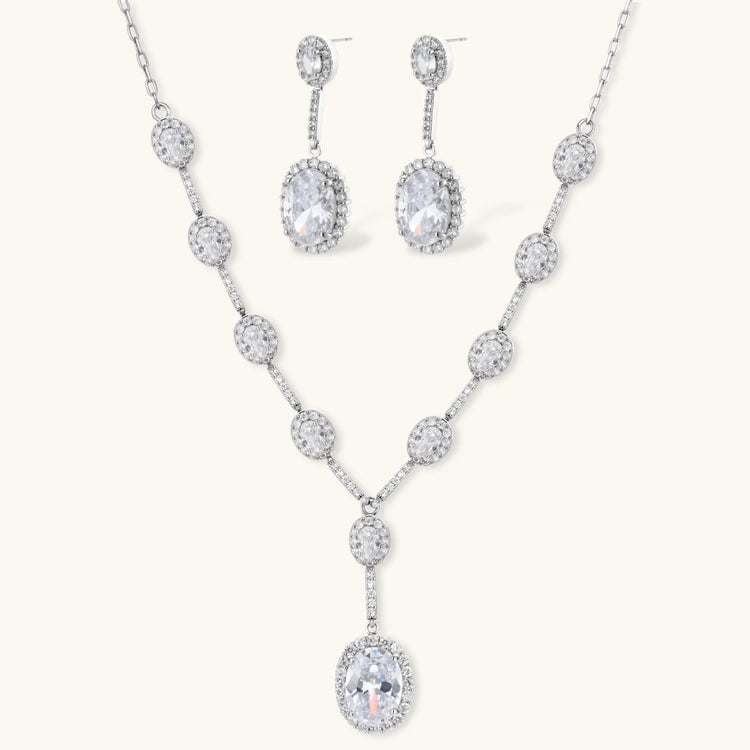 Elegant white gold plated jewelry set with oval cubic zirconia stones in halo settings, featuring Y-necklace and drop earrings.