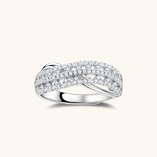 Sterling silver crossover ring with pavé-set moissanite stones creating an elegant infinity design on neutral background