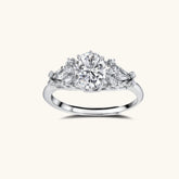 Sterling silver ring with oval moissanite center stone surrounded by smaller accent stones in ornate setting