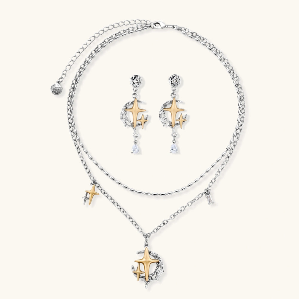 Delicate eco-brass jewelry set featuring gold star and silver moon crescents with clear zirconia crystal drops on cream background