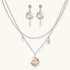 Delicate eco-brass jewelry set featuring gold star and silver moon crescents with clear zirconia crystal drops on cream background