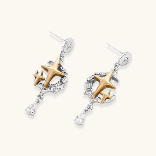 Delicate eco-brass jewelry set featuring gold star and silver moon crescents with clear zirconia crystal drops on cream background