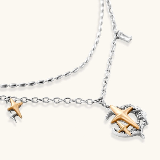 Delicate eco-brass jewelry set featuring gold star and silver moon crescents with clear zirconia crystal drops on cream background