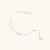 Minimalist bracelet with iridescent baroque pearl on rhodium-plated sterling silver chain against cream background