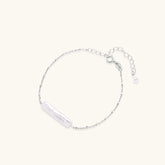 Minimalist bracelet with iridescent baroque pearl on rhodium-plated sterling silver chain against cream background