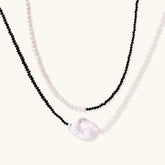 Double-strand necklace with black faceted quartz and white pearls featuring an oversized baroque pearl centerpiece