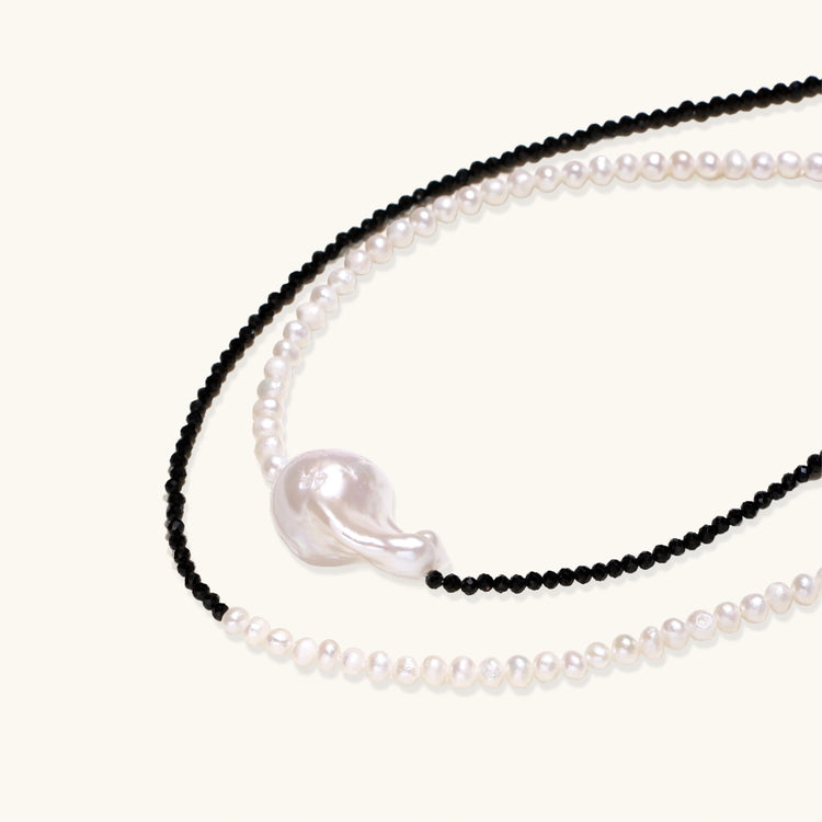 Double-strand necklace with black faceted quartz and white pearls featuring an oversized baroque pearl centerpiece