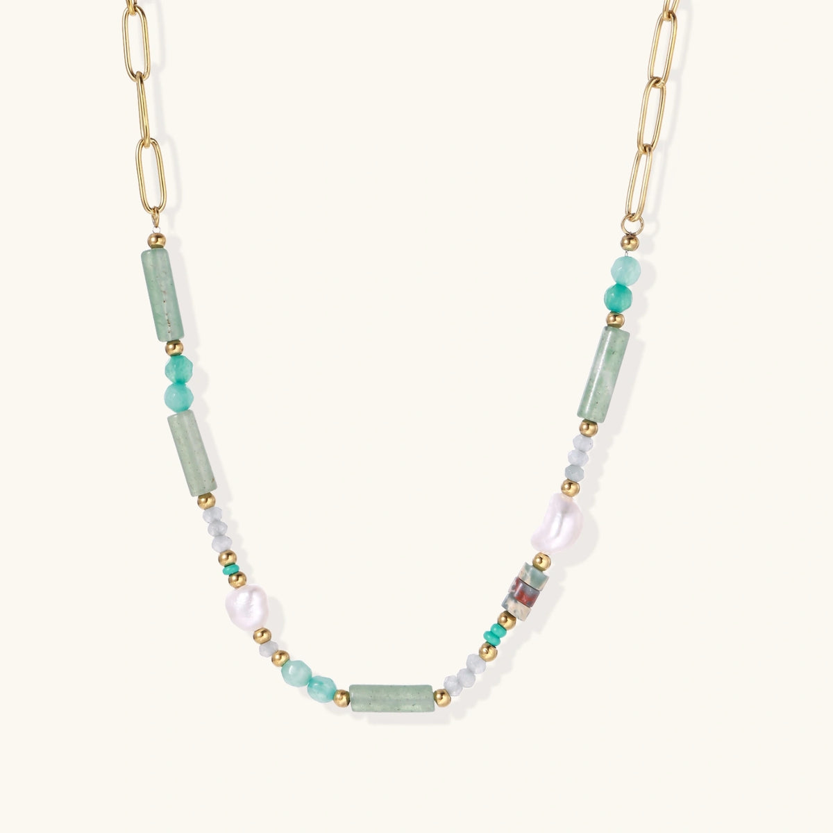 Gold chain necklace with seafoam green quartz cylinders, turquoise beads, and baroque pearl on cream background