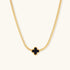 Dainty 18K gold-plated herringbone chain necklace with black enamel quatrefoil clover pendant on white background