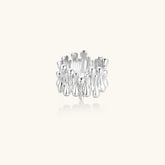 Wide band ring with sculptural wave ripples in polished white gold plated eco-brass on cream background
