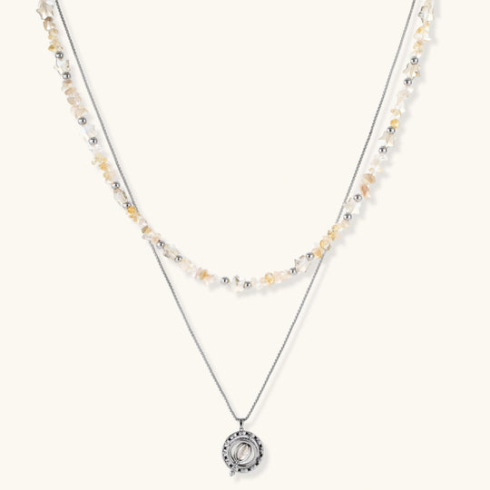 Complete jewelry set featuring citrine stone chips, silver beads, and cosmic circle pendants on cream background.