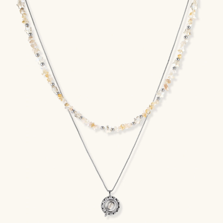 Complete jewelry set featuring citrine stone chips, silver beads, and cosmic circle pendants on cream background.