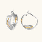 Artistic jewelry set featuring curved silver pendant with gold veining on black cord plus matching asymmetrical hoop earrings