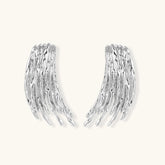 Layered metallic wing-shaped pendant and matching earrings with feathered texture in silver and gold finishes