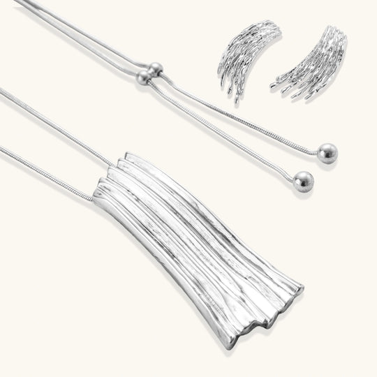 Layered metallic wing-shaped pendant and matching earrings with feathered texture in silver and gold finishes