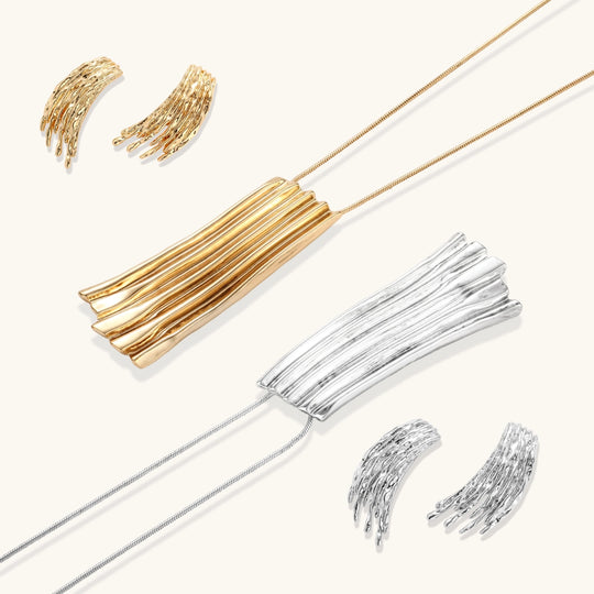 Layered metallic wing-shaped pendant and matching earrings with feathered texture in silver and gold finishes