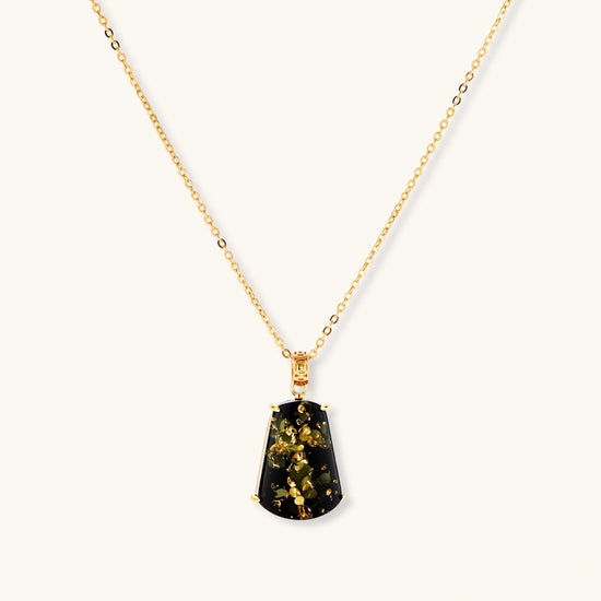 18k gold-plated necklace and earrings with green amber pendants featuring golden inclusions on cream background