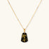 18k gold-plated necklace and earrings with green amber pendants featuring golden inclusions on cream background