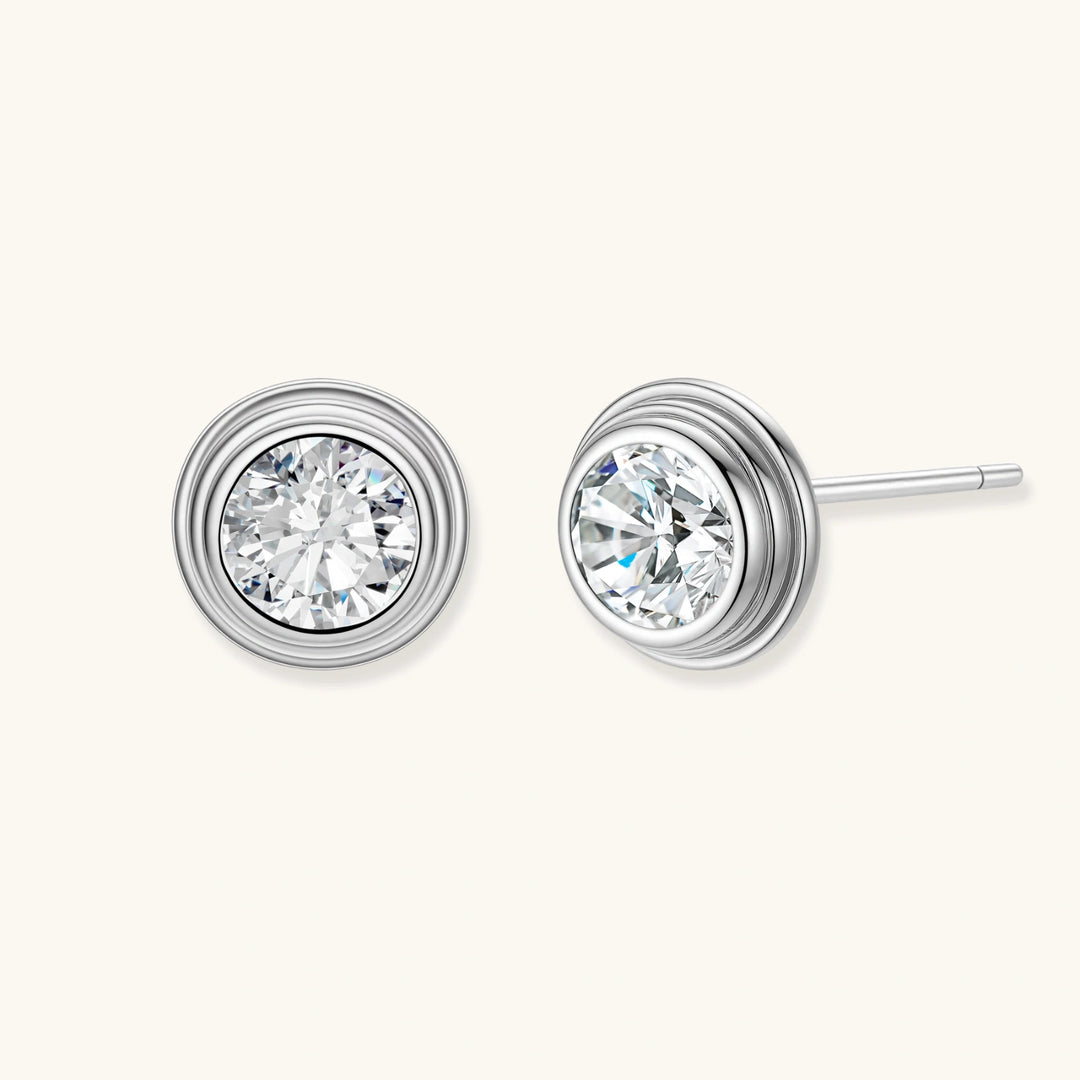 Close-up of sterling silver stud earrings featuring concentric circular frames with brilliant moissanite centers