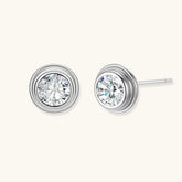 Close-up of sterling silver stud earrings featuring concentric circular frames with brilliant moissanite centers