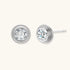 Close-up of sterling silver stud earrings featuring concentric circular frames with brilliant moissanite centers