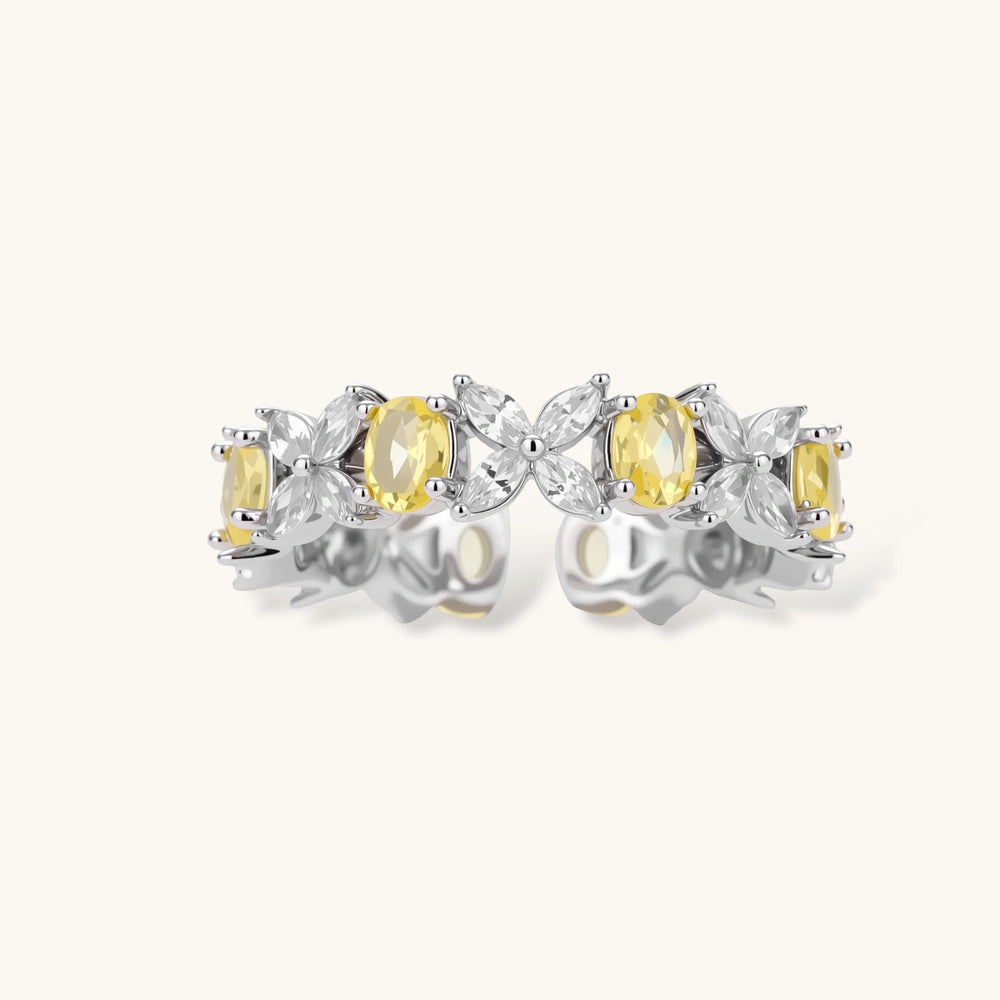 Close-up of platinum-plated copper eternity ring featuring alternating yellow and clear marquise-cut stones in elegant band setting.