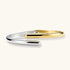 Polished two-tone bypass cuff bracelet in 18K gold plated and silver stainless steel with overlapping tapered ends.