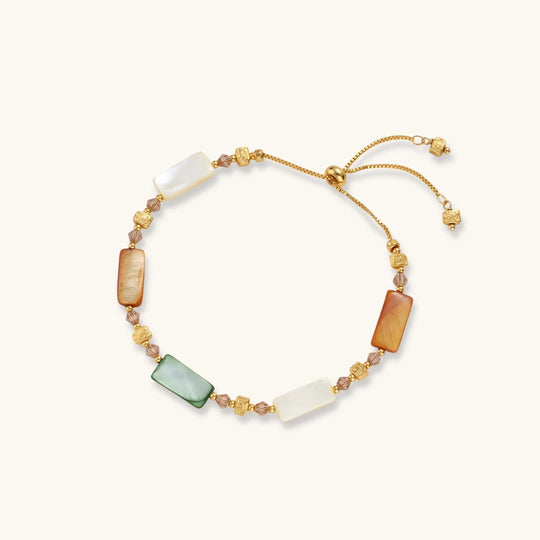 Adjustable gold-plated bracelet featuring rectangular shell beads in green, orange, and white tones on cream background.